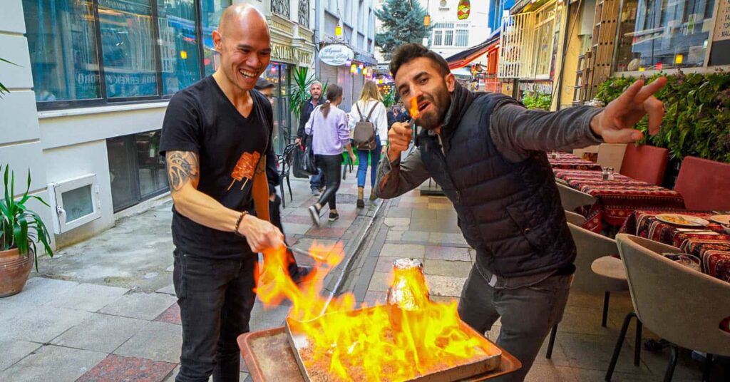 Two men with testi kebab on fire