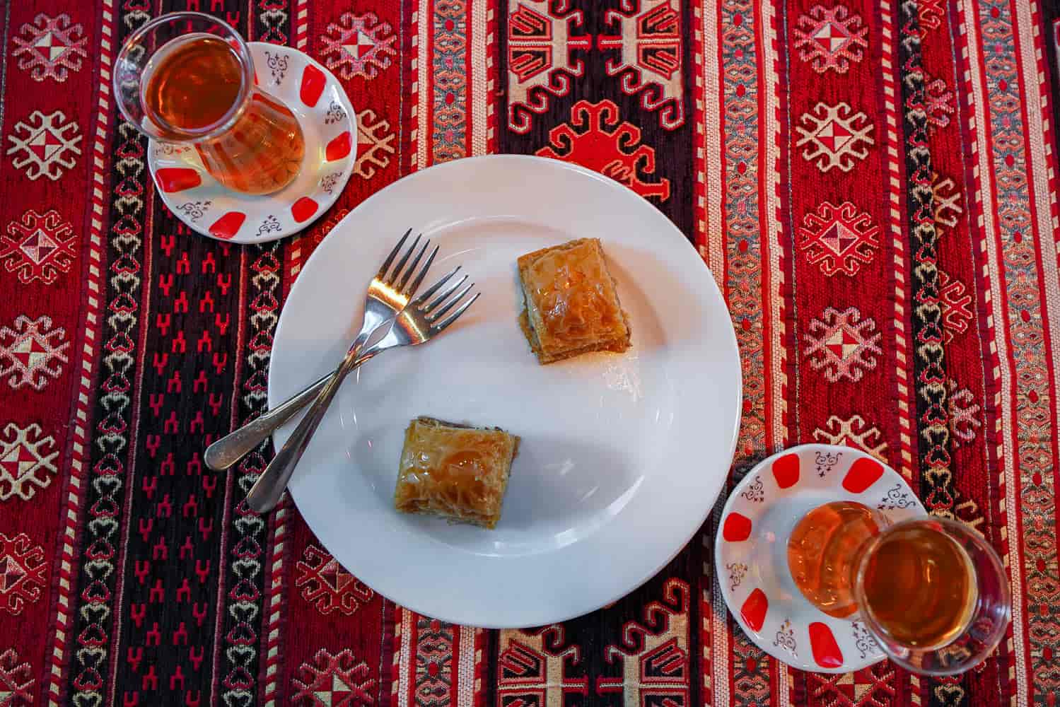 Two baklava on plate with Turkish apple tea