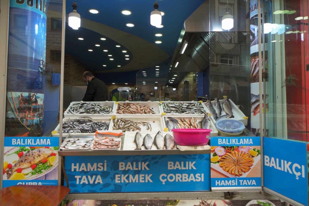 Front of fish shop displaying different kinds of fish in Styrofoam containers