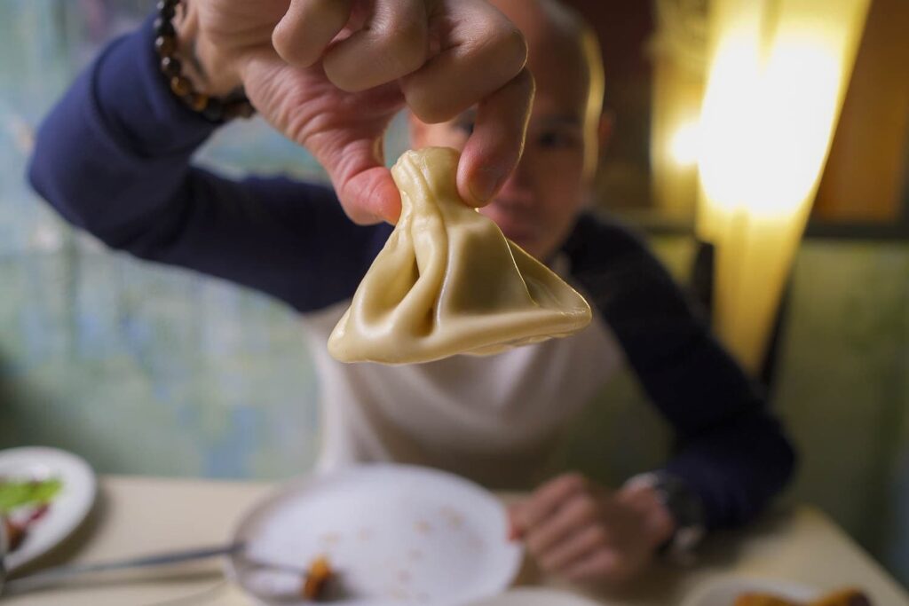 Khinkali held by tail to prepare for eating