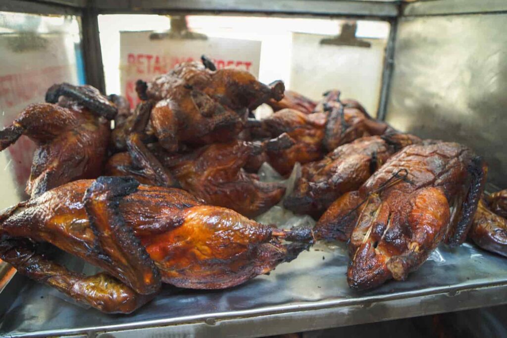 Shelf of whole roasted ducks on hawker cart