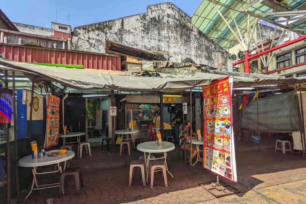 Hon Kee Petaling Street congee restaurant outside building with tables and chairs