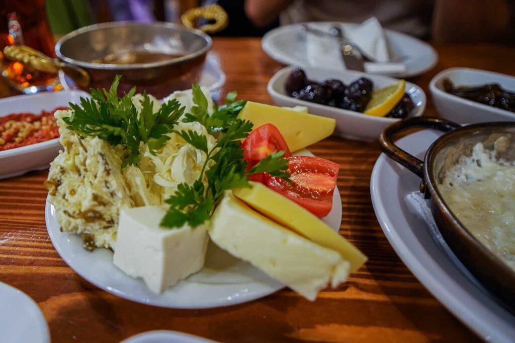 Assortment of traditional Turkish breakfast cheeses with tomatoes and parsley on plate