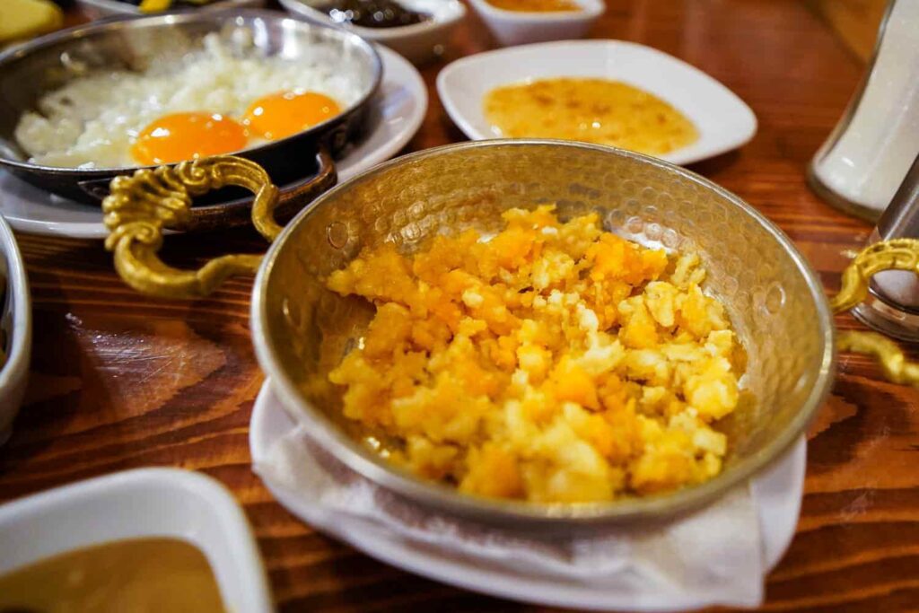 Scrambled eggs with flour in bowl on traditional Turkish breakfast table