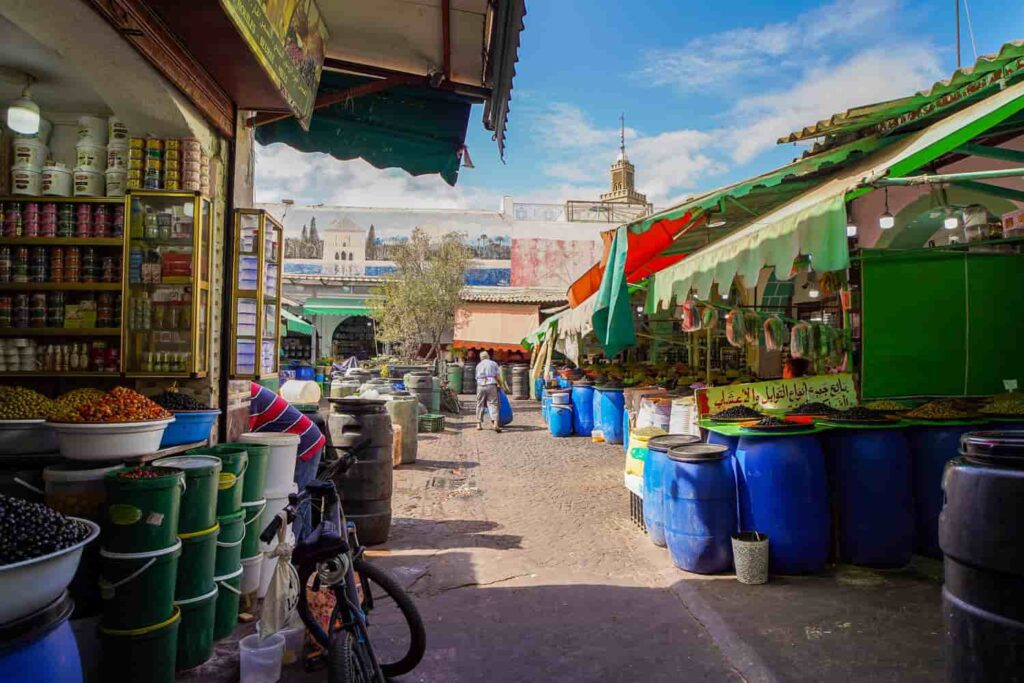 Courtyard of the Great Habous Olive Market with local seller moving barrels of olives