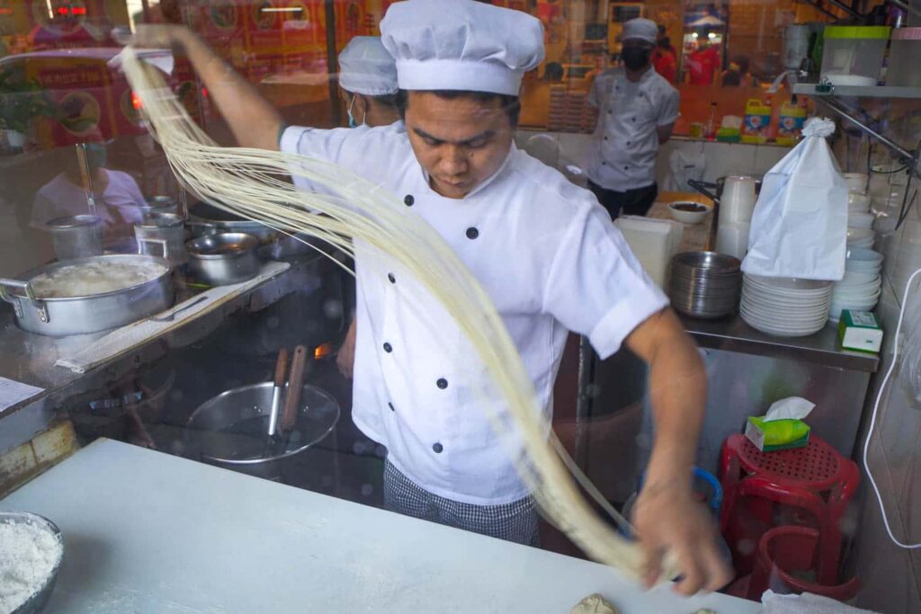 Chef hand pulling noodles