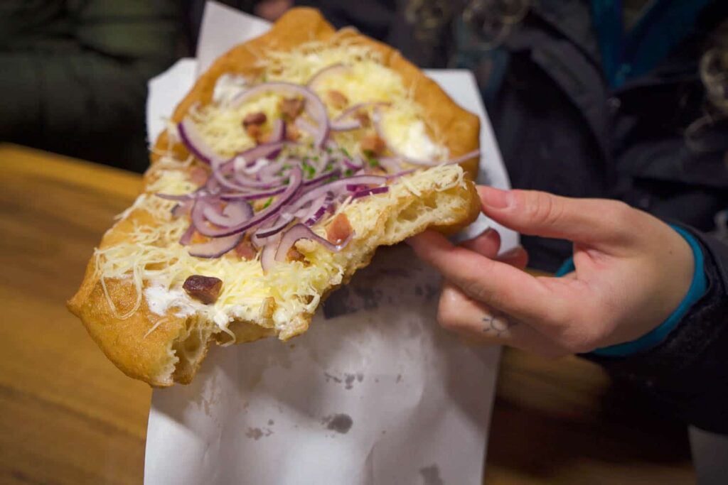Best langos in Budapest covered in toppings ripped in half, centre fluffy