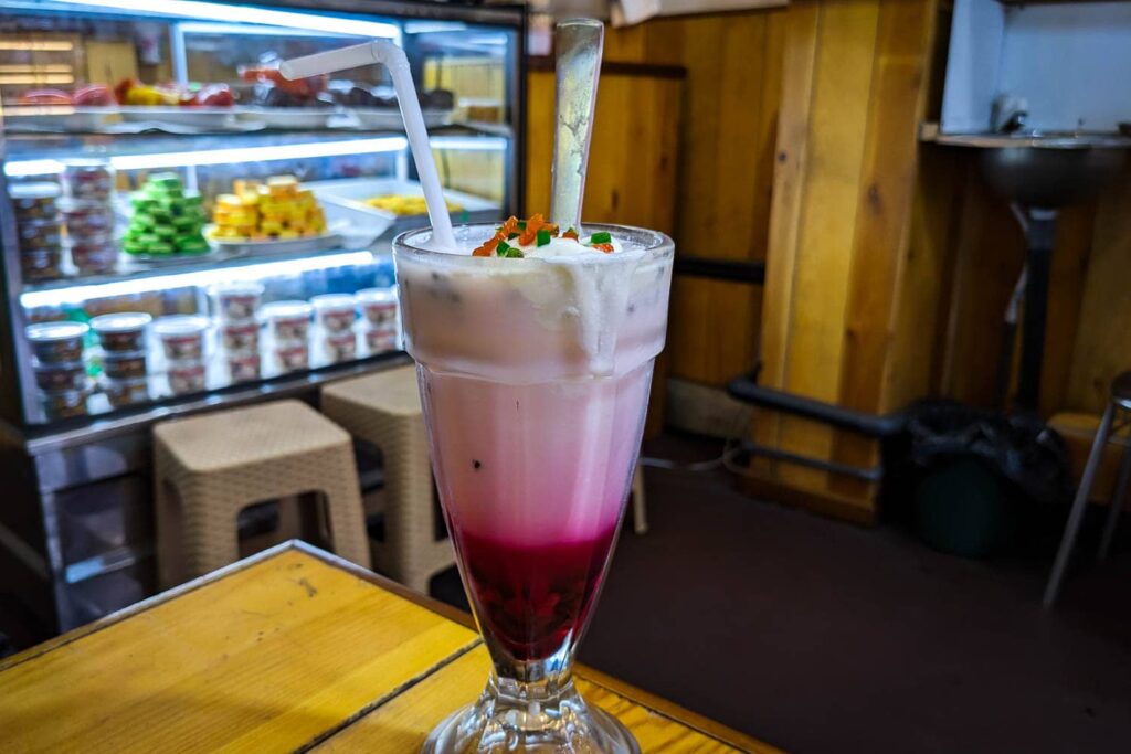 White and pink layered falooda Sri Lankan drink on table in local shop