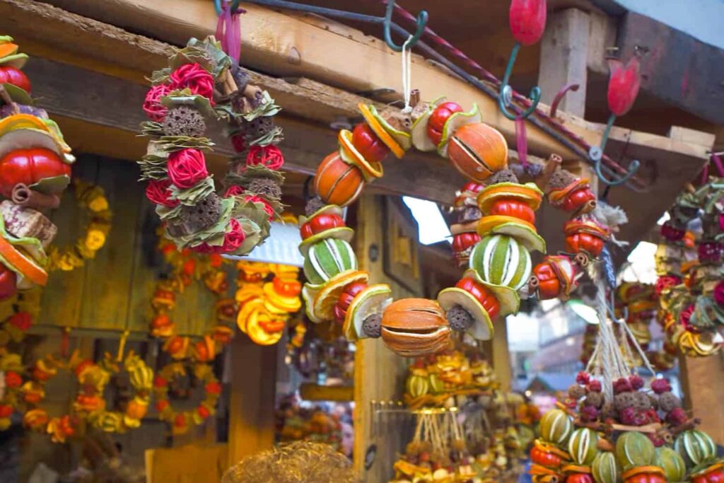 A wooden hut adorned with colourful Christmassy wreaths made of dried fruit.