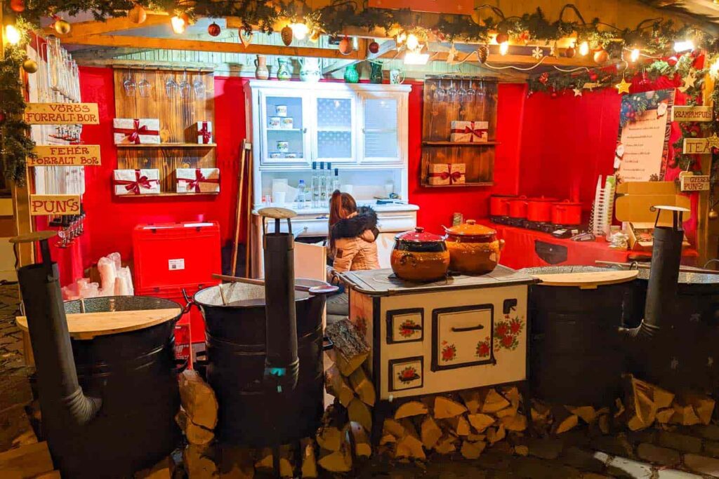 A wooden hut with barrels of mulled wine in the foreground at one of the best Christmas markets in Europe.