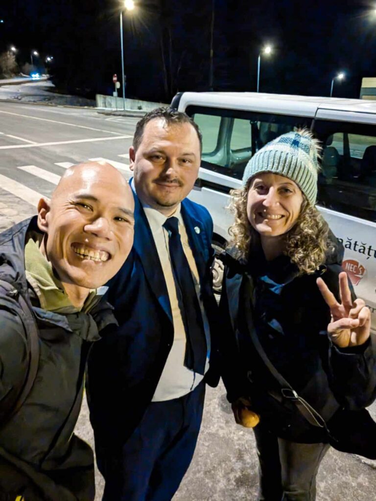Hungry Two Travel smiling taking selfie with Stâna Turistică Sergiana on street outside of Brasov